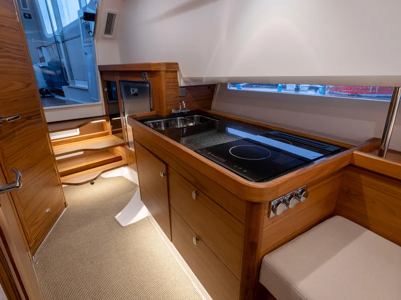 Slide: The Image of Modern kitchen interior in 2024 Nimbus C11 boat, featuring wood cabinetry and sleek appliances. - 10