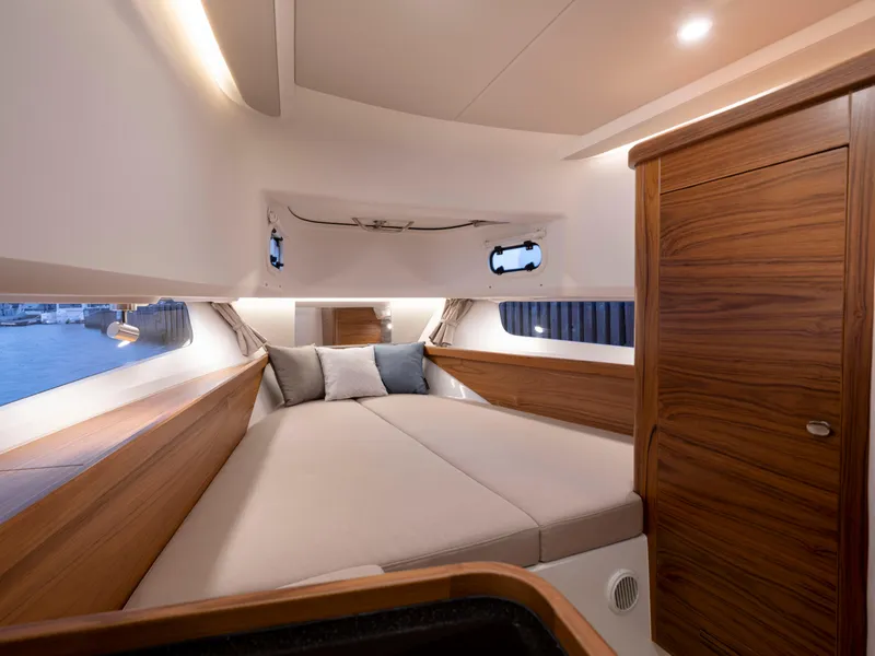Slide: The Image of Luxurious cabin interior of 2024 Nimbus C11 boat with cozy bed and wooden accents. - 12