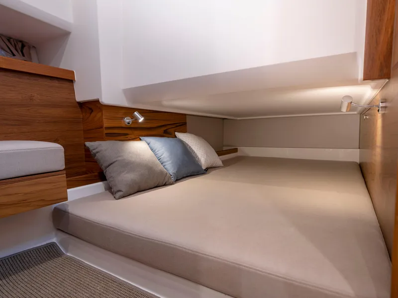 Slide: The Image of 2024 Nimbus C11 cabin interior with cozy bed and wooden accents. - 13