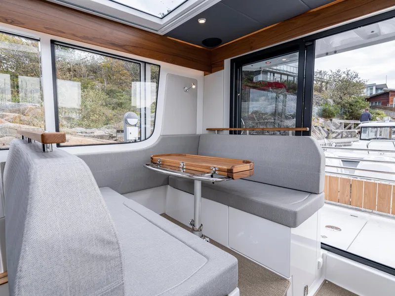 Slide: The Image of 2024 Nimbus C11 boat interior with gray seating and wooden accents. - 5