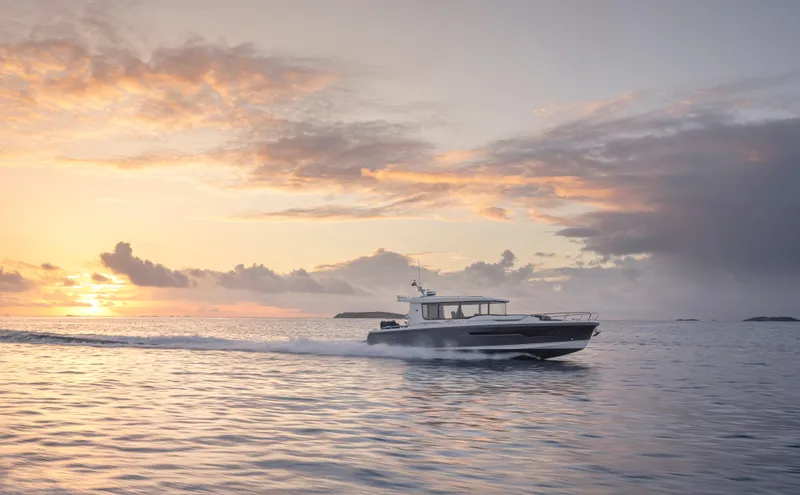 Slide: The Image of Nimbus C11 2024 boat cruising at sunset on calm ocean waters. - 2