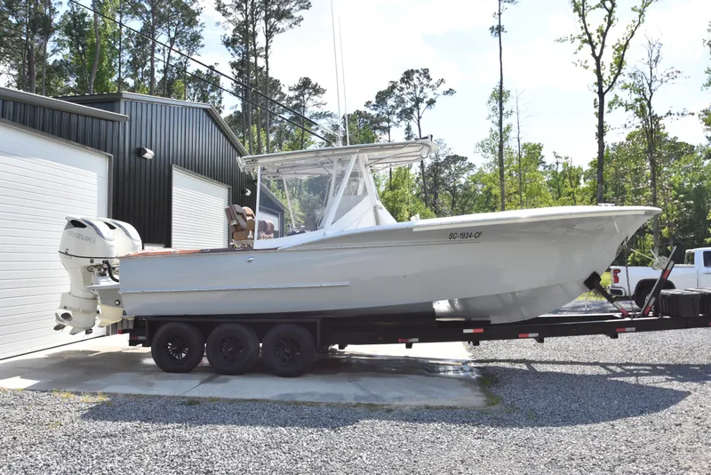 The Image of Custom Carolina 28 Cape Lookout boat on trailer, 2007 model with 2019 repower, parked outdoors. - 0