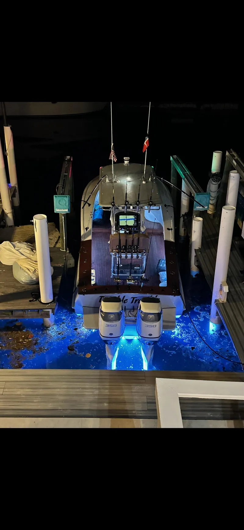 Slide: The Image of Custom Carolina 28 Cape Lookout boat docked at night, illuminated with blue underwater lights. - 3