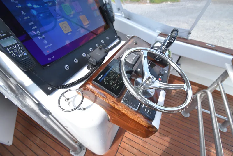 Slide: The Image of Helm of 2007 Custom Carolina 28 Cape Lookout boat, featuring modern controls and touchscreen display. - 30