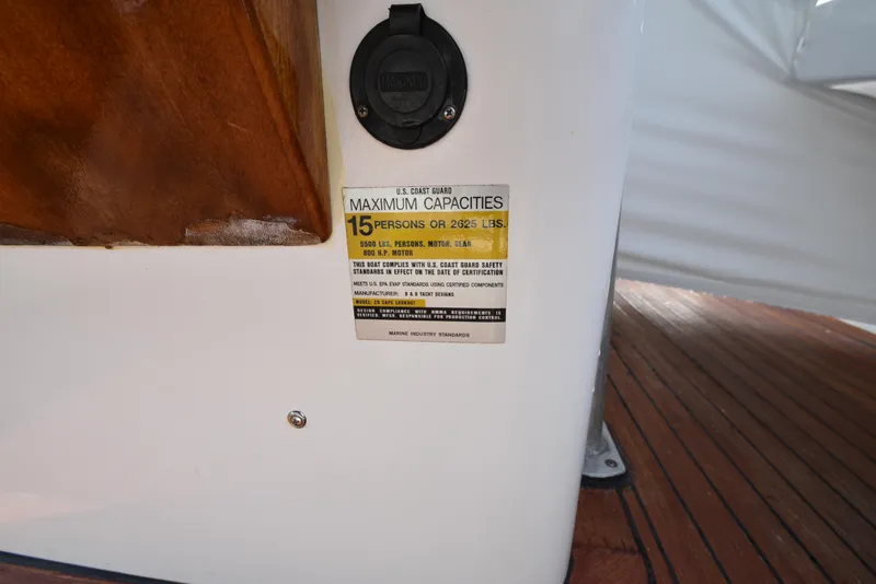 Slide: The Image of Custom Carolina 28 Cape Lookout boat capacity label, 15 persons or 2625 lbs, wood and deck visible. - 34