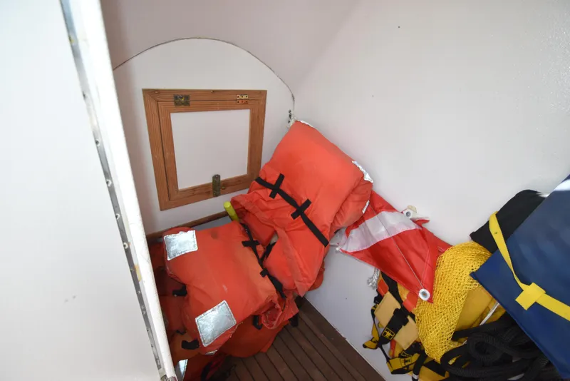 Slide: The Image of Storage area with life jackets and safety gear on a 2007 Custom Carolina 28 Cape Lookout boat. - 37