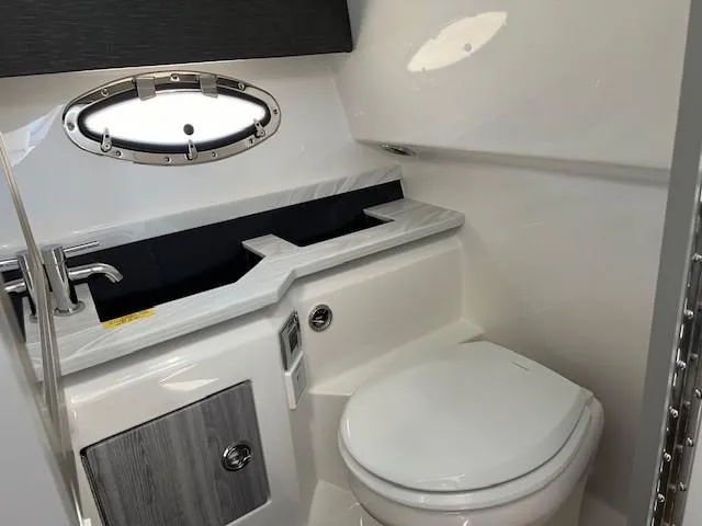Slide: The Image of 2025 Formula 330 Crossover Bowrider I/O bathroom with modern sink and toilet. - 15