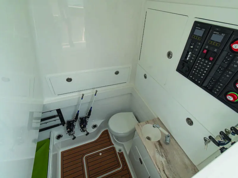 Slide: The Image of Valhalla Boatworks V-41 2025 interior cabin with fishing rods, control panels, and toilet. - 23