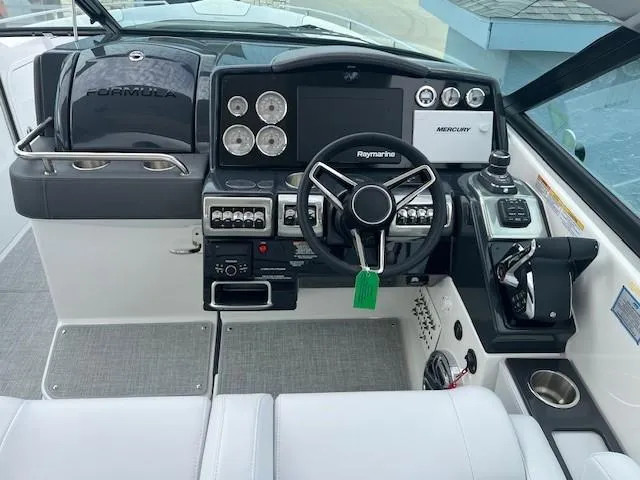 Slide: The Image of 2025 Formula 350 Crossover Bowrider I/O dashboard with steering wheel, controls, and navigation system. - 12