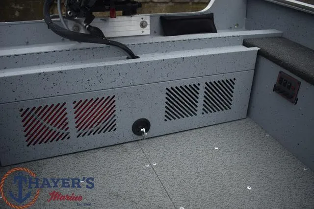 Slide: The Image of 2024 Lund 1600 Fury Tiller boat interior with storage compartments and control panel. - 15