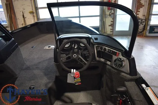 Slide: The Image of 2024 Lund 1875 Impact XS Sport boat interior with steering wheel and dashboard. - 10