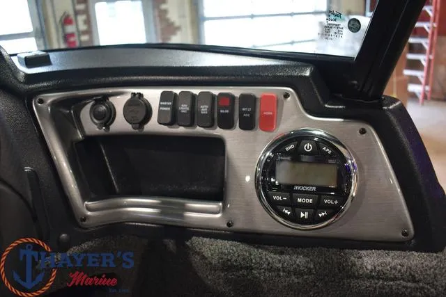 Slide: The Image of 2024 Lund 1875 Impact XS Sport dashboard with control panel and Kicker audio system. - 11