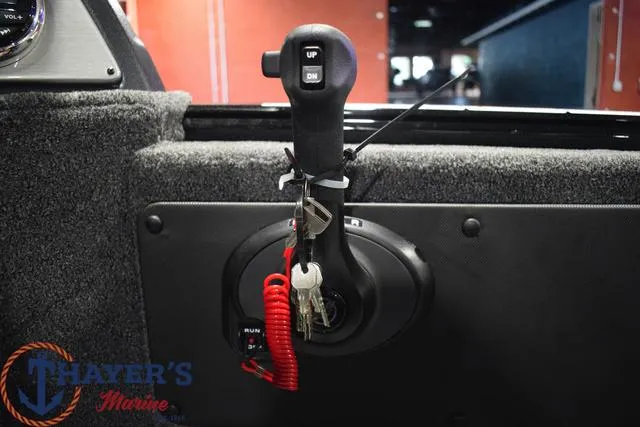 Slide: The Image of Throttle control of 2024 Lund 1875 Impact XS Sport boat with keys and safety lanyard. - 12