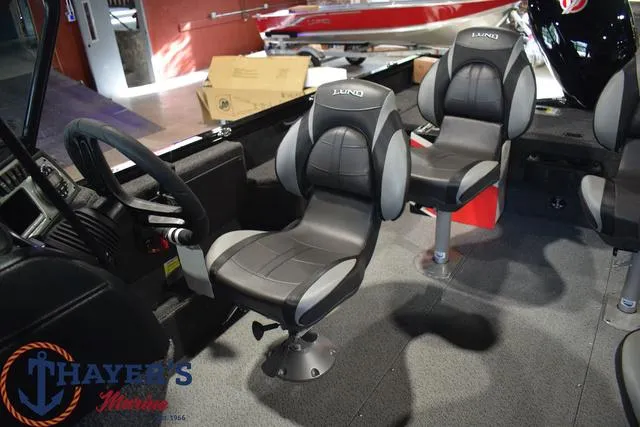 Slide: The Image of 2024 Lund 1875 Impact XS Sport boat interior with steering wheel and seating. - 16