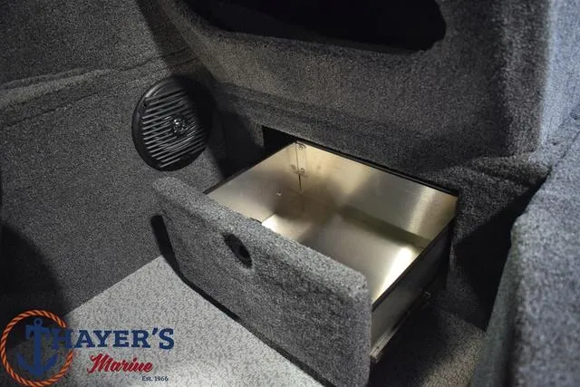 Slide: The Image of 2024 Lund 1875 Impact XS Sport interior storage compartment with Thayer's Marine logo. - 22