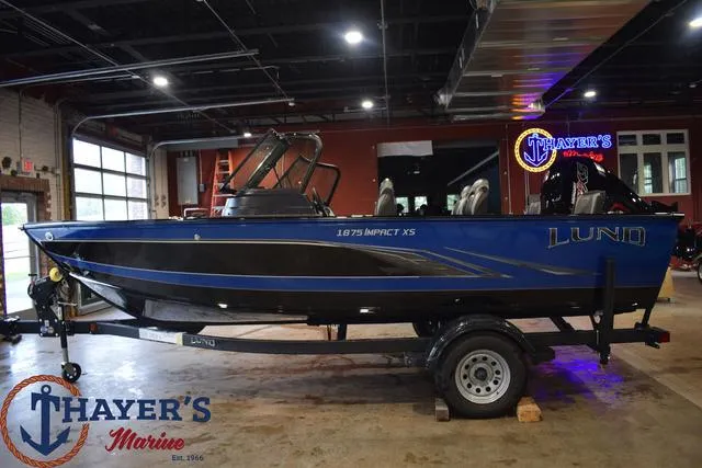 Slide: The Image of 2024 Lund 1875 Impact XS Sport boat on trailer at Thayer's Marine showroom. - 28