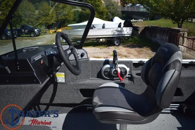 Slide: The Image of 2024 Lund 1675 Adventure Sport boat interior with steering wheel and captain's chair. - 10