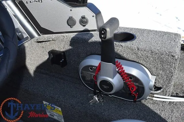 Slide: The Image of 2024 Lund 1650 Angler Sport boat control panel with throttle and ignition. - 11