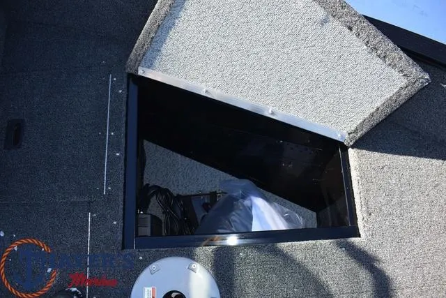 Slide: The Image of 2024 Lund 1650 Angler Sport boat storage compartment with open hatch. - 15