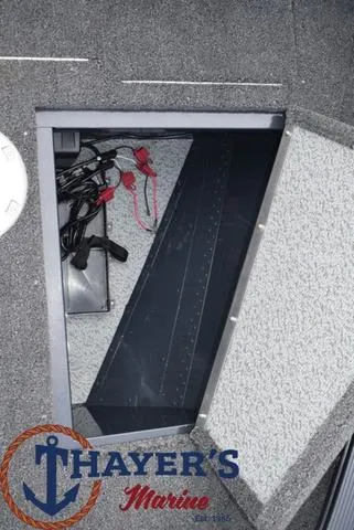 Slide: The Image of 2024 Lund 1650 Angler Sport boat storage compartment with Thayer's Marine logo. - 10
