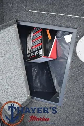 Slide: The Image of 2024 Lund 1650 Angler Sport storage compartment with Thayer's Marine logo. - 11