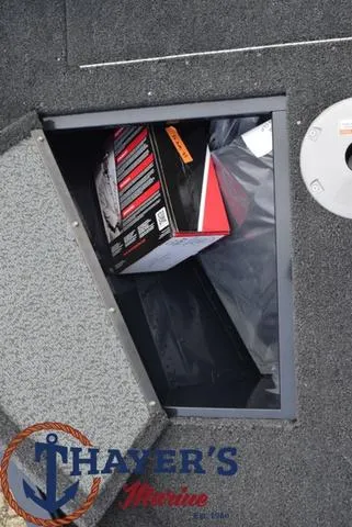 Slide: The Image of 2024 Lund 1650 Angler Sport storage compartment with Thayer's Marine logo. - 12