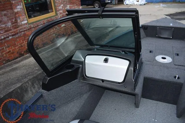 Slide: The Image of 2024 Lund 1650 Angler Sport boat interior with open windshield and storage compartment. - 19