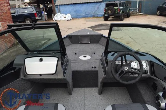 Slide: The Image of 2024 Lund 1650 Angler Sport boat interior with steering console and seating. - 20