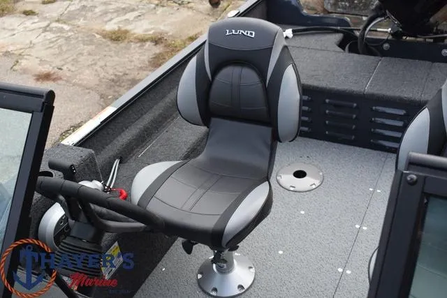 Slide: The Image of 2024 Lund 1650 Angler Sport boat interior with captain's chair and steering console. - 23