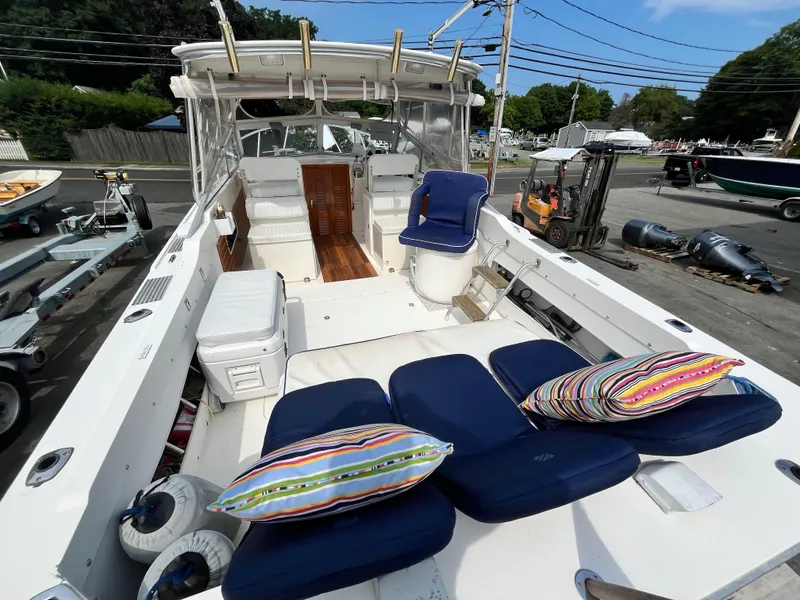 Slide: The Image of 1977 Bertram 26 Moppie boat interior with blue seating and colorful pillows. - 10