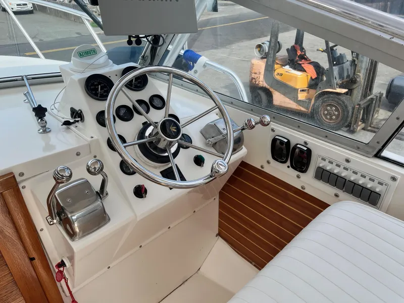 Slide: The Image of 1977 Bertram 26 Moppie boat cockpit with steering wheel and control panel. - 11