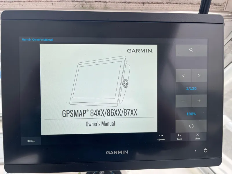Slide: The Image of Garmin GPSMAP owner's manual displayed on a screen, model 84XX/86XX/87XX. - 12