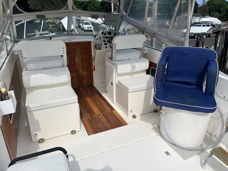 Slide: The Image of 1977 Bertram 26 Moppie boat interior with white seating and blue cushioned chair. - 16