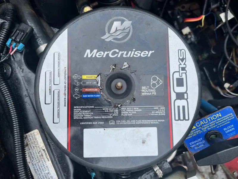 Slide: The Image of MerCruiser 3.0 TKS engine in a 1977 Bertram 26 Moppie boat, showing specifications and caution label. - 23