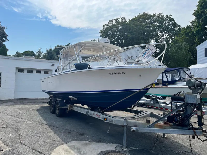 Slide: The Image of 1977 Bertram 26 Moppie boat on trailer, parked outdoors near a garage. - 3