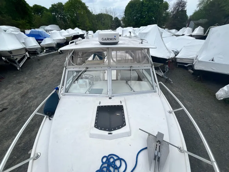 Slide: The Image of 1977 Bertram 26 Moppie boat with Garmin equipment, docked among covered boats. - 6