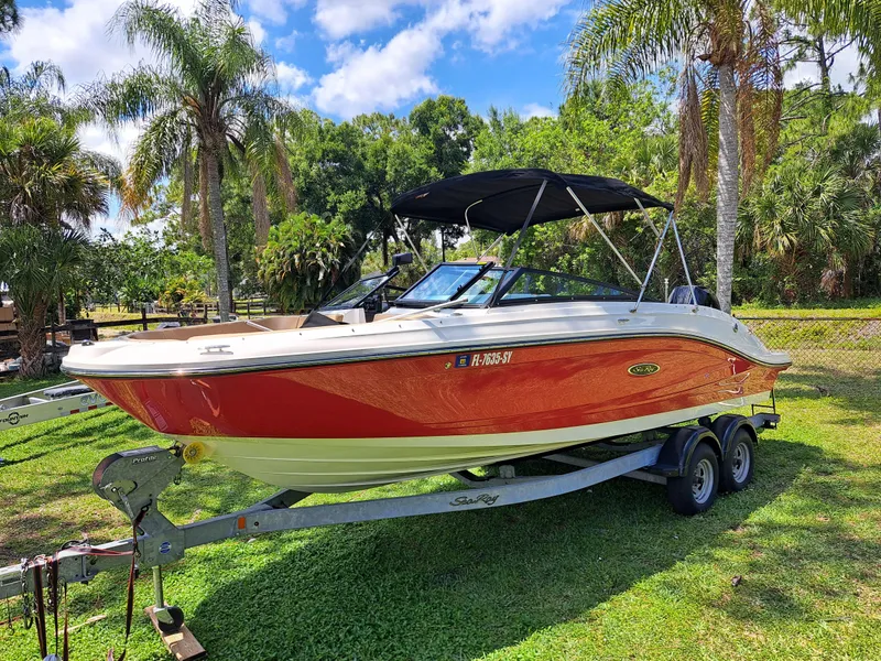 The Image of 2019 Sea Ray SPX 230 OB boat on a trailer with palm trees in the background. - 0