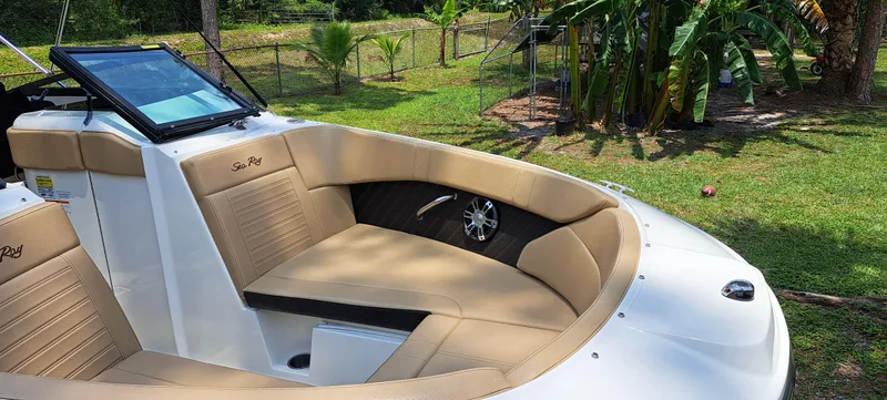 Slide: The Image of 2019 Sea Ray SPX 230 OB boat with tan seating in a lush green yard. - 13
