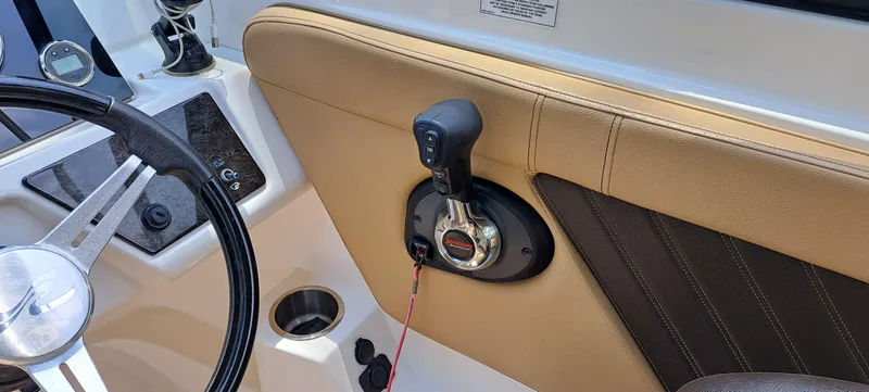 Slide: The Image of 2019 Sea Ray SPX 230 OB boat interior, steering wheel, and throttle control. - 19