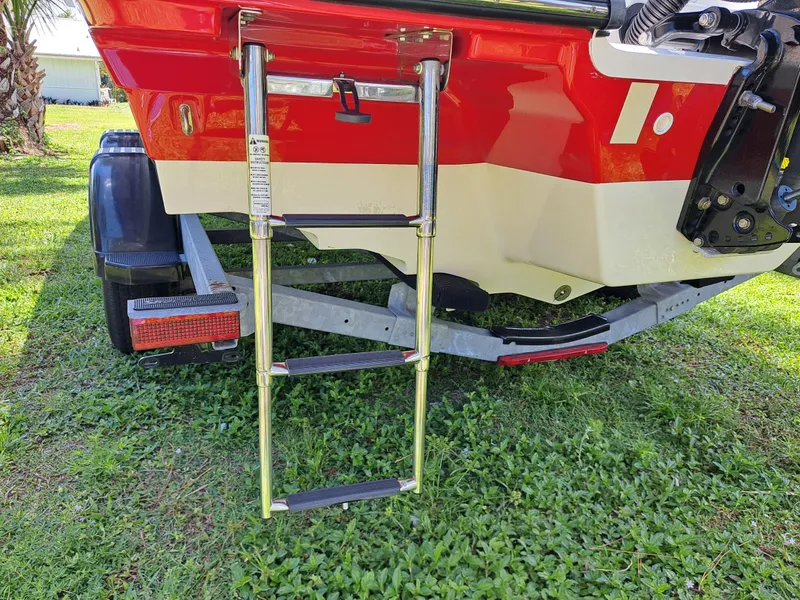 Slide: The Image of 2019 Sea Ray SPX 230 OB boat with extended swim ladder and trailer. - 47