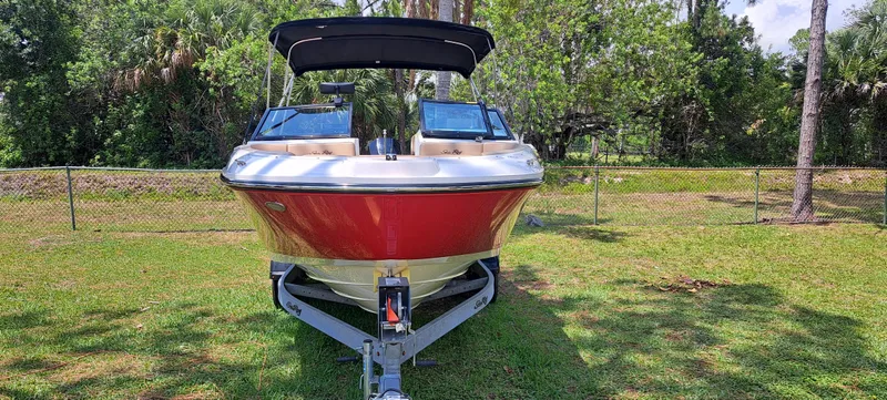 Slide: The Image of 2019 Sea Ray SPX 230 OB boat on trailer, front view, parked on grass. - 9