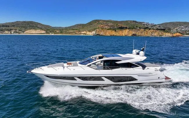 Slide: The Image of 2018 Sunseeker Predator 74 yacht cruising on open water, scenic coastal backdrop. - 1