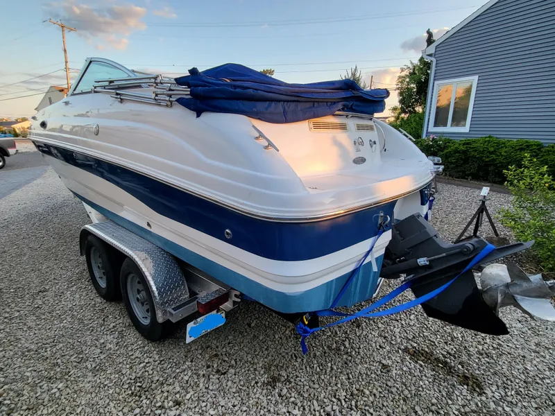 Slide: The Image of 2002 Chaparral Sunesta 233 boat on trailer, parked on gravel driveway. - 12