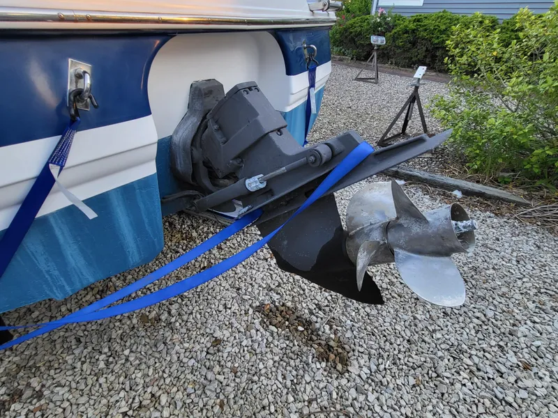 Slide: The Image of 2002 Chaparral Sunesta 233 boat propeller and stern, parked on gravel. - 13