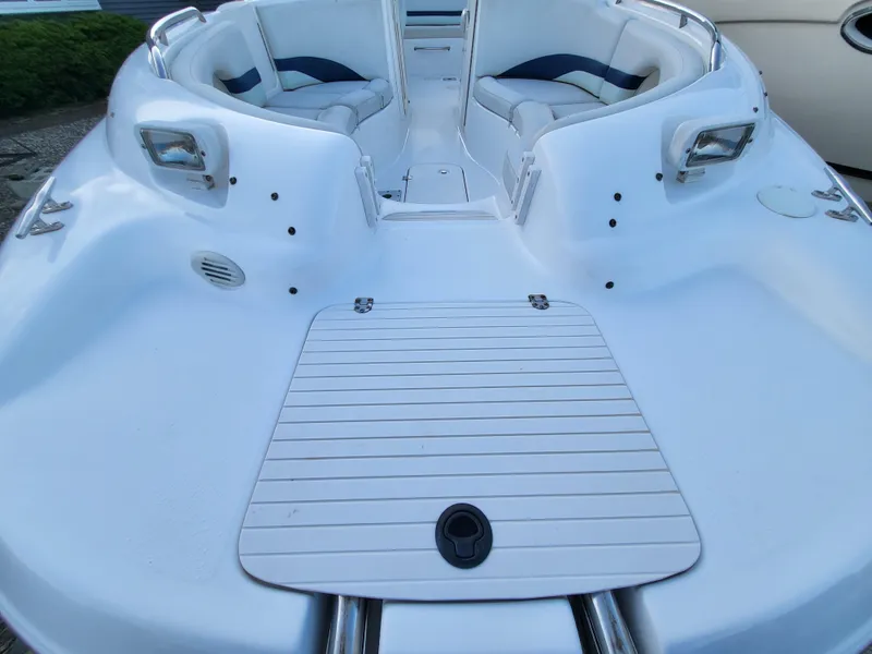 Slide: The Image of 2002 Chaparral Sunesta 233 boat interior with white seating and deck. - 17