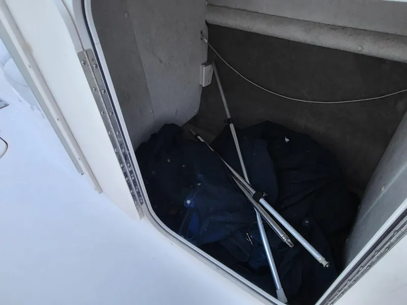 Slide: The Image of Storage compartment in a 2002 Chaparral Sunesta 233 boat with poles and fabric. - 23