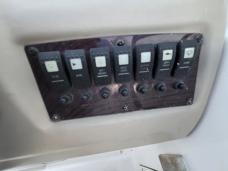 Slide: The Image of Control panel of a 2002 Chaparral Sunesta 233 boat with various switches. - 28