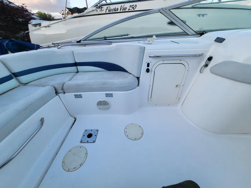 Slide: The Image of 2002 Chaparral Sunesta 233 boat interior with white seating and storage compartments. - 32