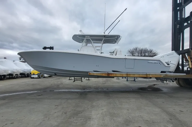 Slide: The Image of 2024 Invincible 36 boat on a forklift at a marina, cloudy sky background. - 3