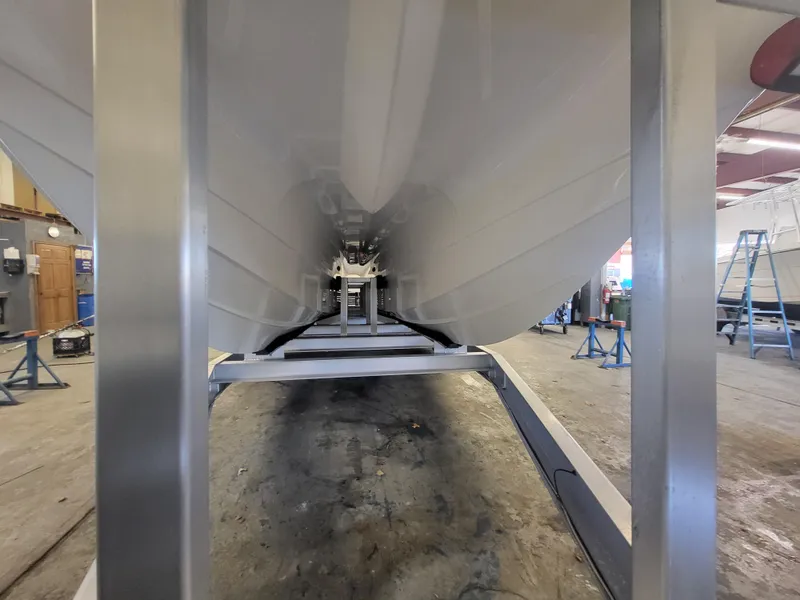 Slide: The Image of 2024 Caymas 34 CT boat hull in a workshop. - 10